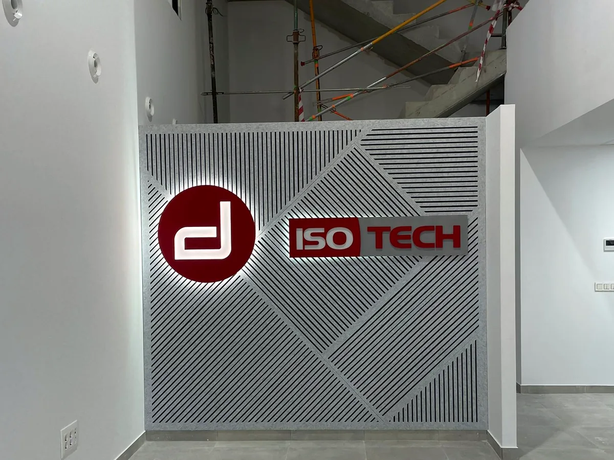 Logotipo de cliente integrado en un panel acústico cortado en V con líneas