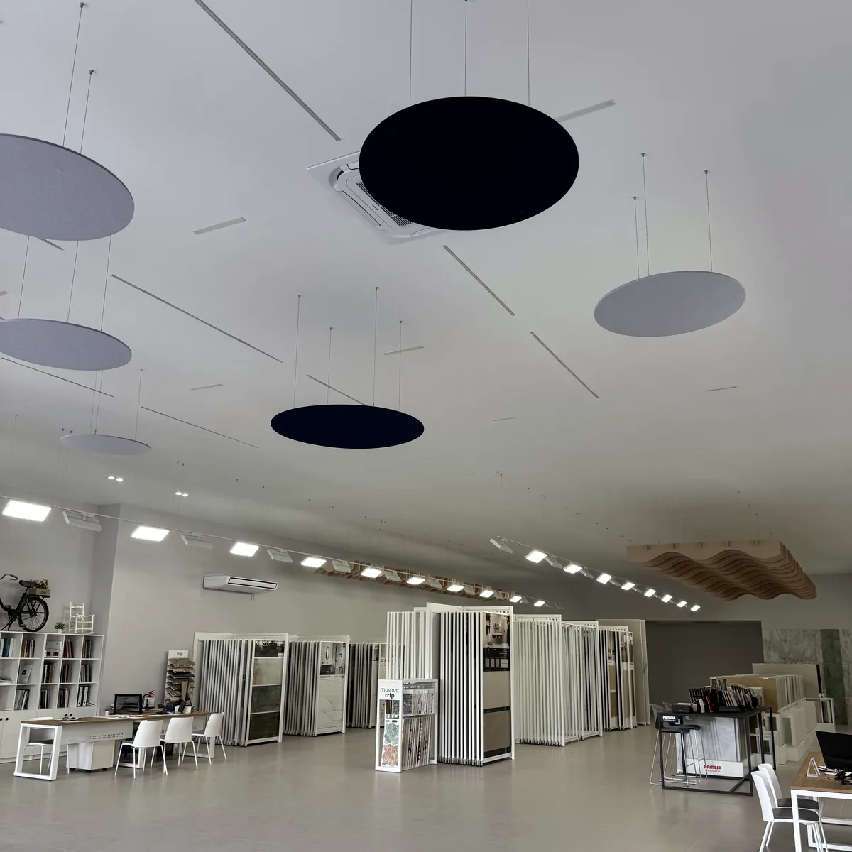Discos acústicos elípticos suspendidos en una sala diáfana