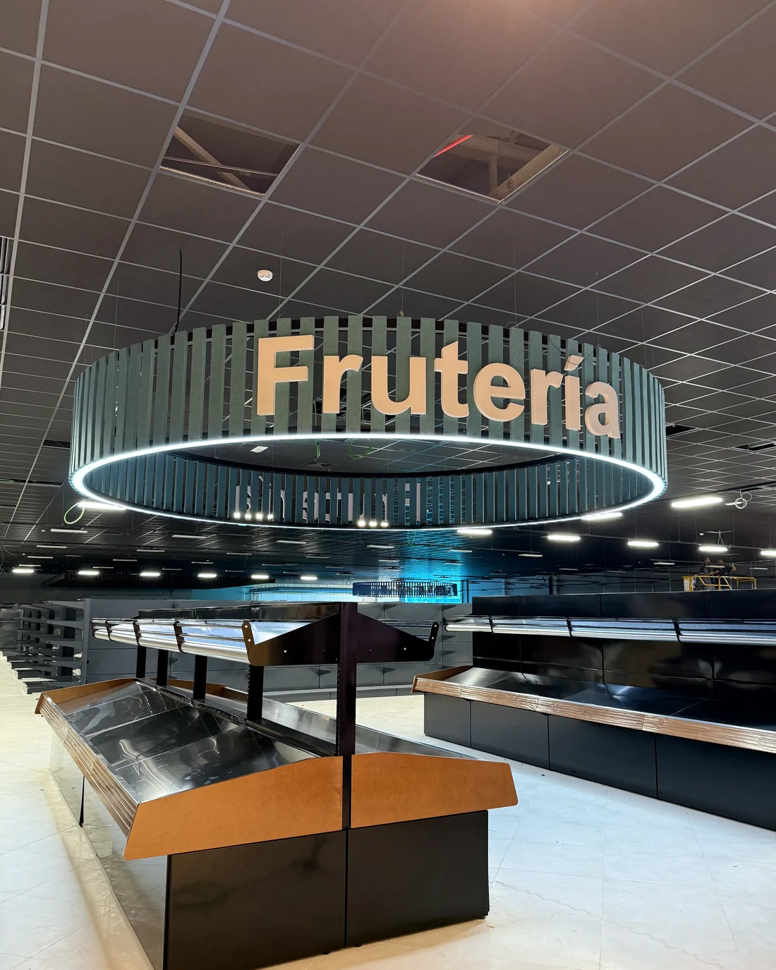 Supermercado con luminaria circular de lamas sobre la zona de fruta