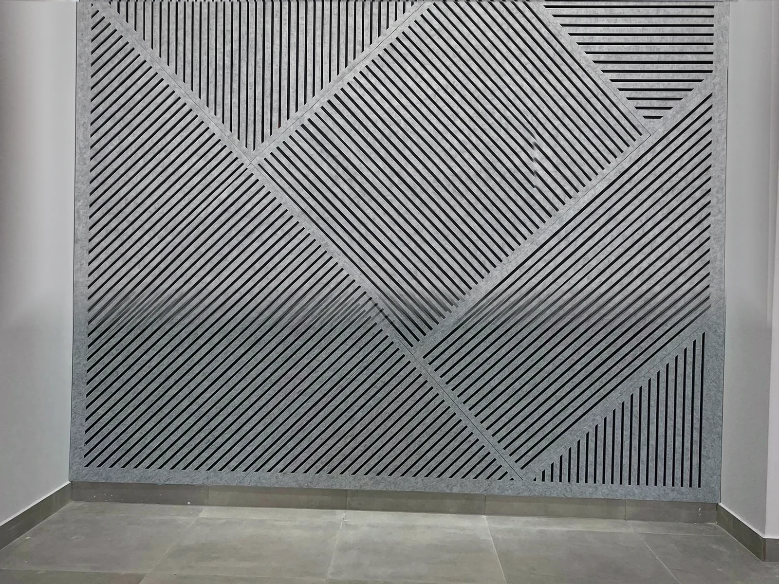 Pared de panel acústico VIVA con geometría de líneas en V CUT